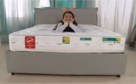 Bambino seduto felice su un materasso per l'infanzia